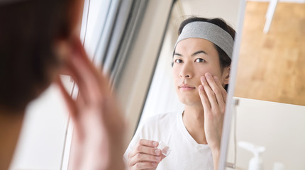 顔にクリームを塗る男性