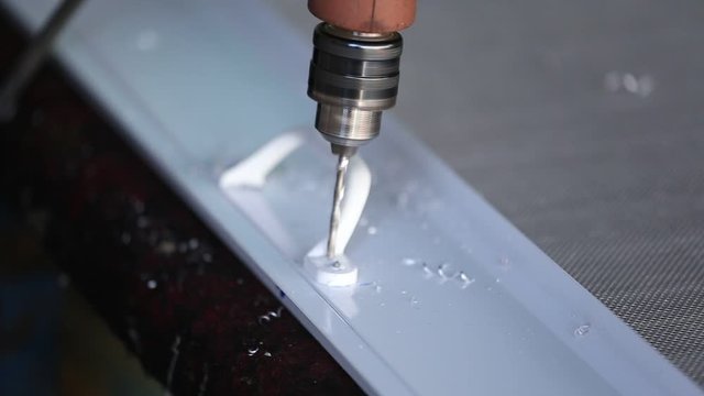 Mechanic is drilling aluminum by using a small drill to drill aluminum.