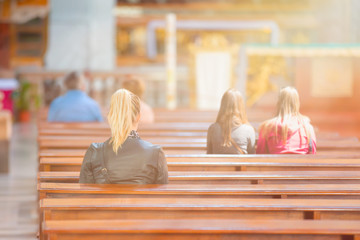 People praying in a church with sunrays