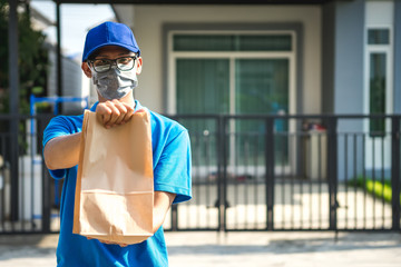 Asian delivery man wearing mask delivers parcel, customer in medical gloves signs on tablet. Delivery service under quarantine, disease outbreak, coronavirus covid-19 pandemic conditions.