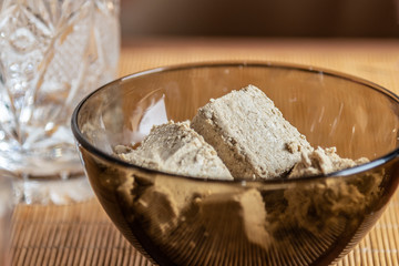 Sunflower halva in a glass bowl on a bamboo napkin