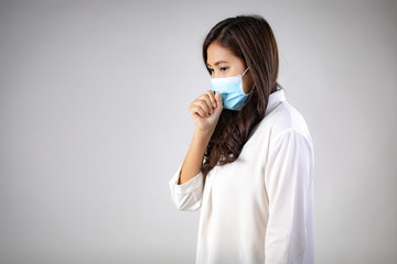 Portrait of Asian Sick woman with protective mask coughing on white background. Mask protection against virus. Covid-19, coronavirus pandemic