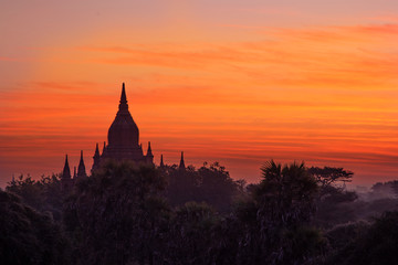 Obraz premium Morning sunrise on a famous buddhist temple with a misty foggy forest in Bagan, Myanmar