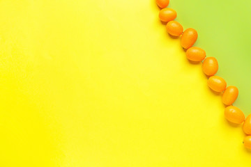 Tasty kumquat fruit on color background