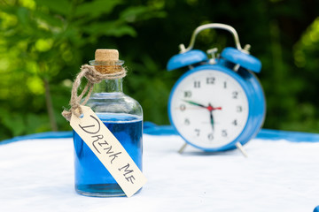 An old closed bottle with a strange blue liquid with a label that says: drink me. Filmed based on...