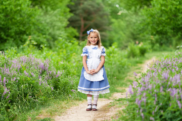Portrait of a little cute girl dressed as Alice. Stylized photo shoot in nature.