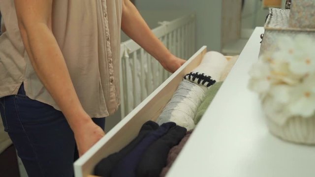Woman taking clothes from her tidy  commode