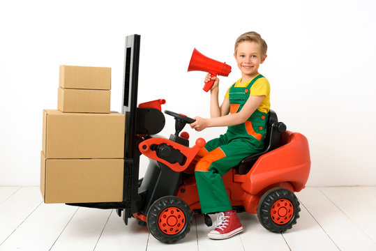 A boy in a forklift like a warehouse worker, supplier, courier.