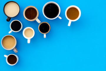 Many cups of coffee on blue table top-down copy space
