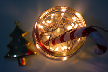 Close-up Of Illuminated Christmas Lights And Candy Cane In Glass Jar
