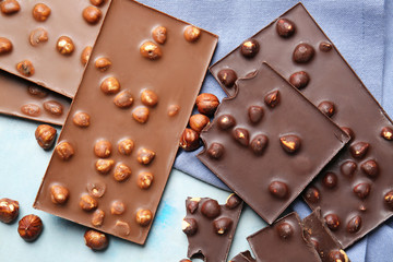 Sweet chocolate with nuts on color background