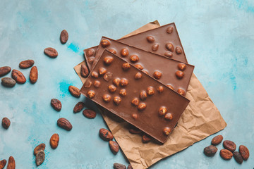 Sweet chocolate with nuts on color background