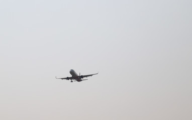 Closeup of an airplane flying to the destination airport with twilight sky background,