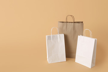 Paper shopping bags on color background
