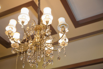 The lamp in the beautiful room .Brass chandelier with crystal. Chandelier ceiling lights . Chandelier Lamp beautiful luxury expensive chandelier hanging under ceiling .