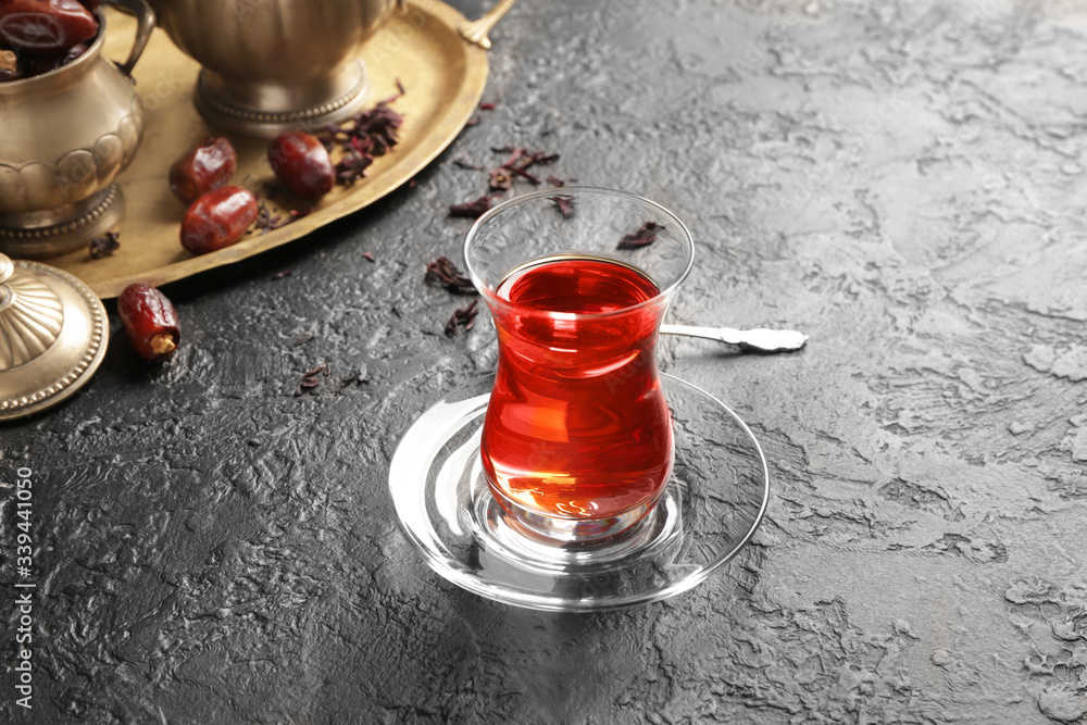 Wall mural Glass of tasty Turkish tea on dark background