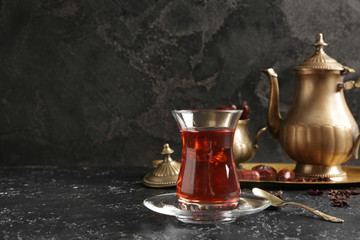 Glass of tasty Turkish tea on dark background