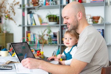 Young attractive father freelance worker working home with baby