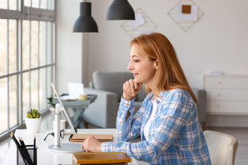 Mature woman using tablet computer for online learning at home