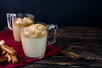 Delicious and fragrant dalgona coffee in glass cups, cinnamon sticks, dried mushrooms, a spoon of instant coffee, sugar.