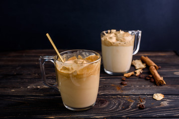 Delicious and fragrant dalgona coffee in glass cups, cinnamon sticks, dried mushrooms, a spoon of instant coffee, sugar.
