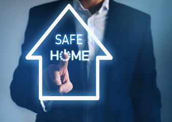 Businessman pointing house symbol with text SAFE Home. Protection campaign or measure from coronavirus, COVID-19.Coronavirus, COVID-19 protection. Save your Business from home.