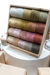Fototapeta na wymiar Colorful yarn on spool, yarn on tube, cotton, wool, linen thread on wooden shelf.