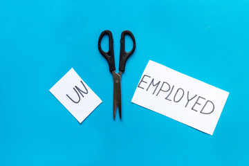 Unemployed - employed - torn paper sheet, sciccors on blue background top view. Hiring concept.
