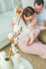 Beautiful young parents are holding their little newborn daughter in their arms. Blue-eyed little girl of 2 months. Baby