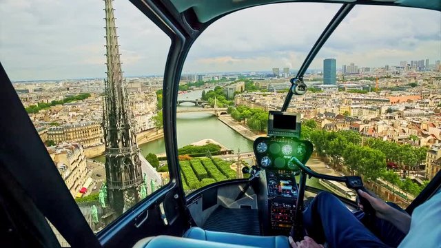 Helicopter flying on the roof of Notre Dame church spotting its spire, in Paris panorama, French capital, Europe. Scenic flight over Paris cityscape.