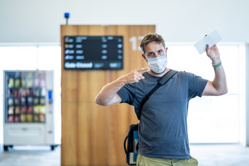 Traveler with mask stuck in airport no able to return home country due to COVID-19 border closures.