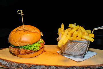 a crispy breaded chicken burger served alongside a portion of French fries 
