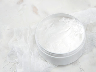 White medical cream in a jar on a white background