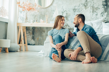 Obraz premium Barefooted couple in the bedroom having pleasant talk stock photo