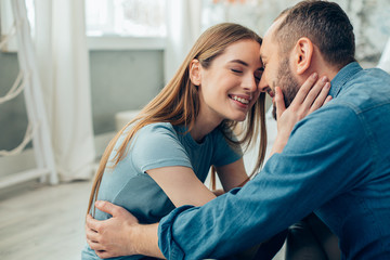 Man and woman cuddling at home and looking romantic stock photo