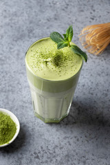 Dalgona Iced Matcha tea. Whipped white eggs with matcha tea is added to milk with ice. Tasty viral drink in time self-isolation. Vertical format.
