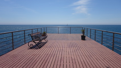 Fototapeta na wymiar Pier with a bench on the beach