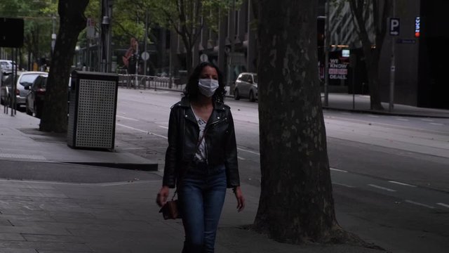 Woman walking down bourke st wearing mask during covid19 Melbourne