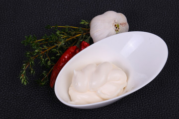 Mayonnaise sauce in the white bowl served thyme and garlic