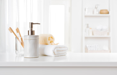 Fototapeta na wymiar Soap dispenser, toothbrushes and white towel on bathroom counter interior