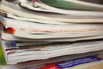 a stack of glossy magazines is on the table
