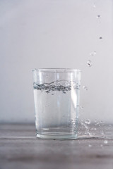 Large drops of water from above into a glass of water. Drink macro photography
