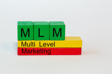 MLM is the abbreviation of Multi Level Marketing and stands on colorful toy blocks isolated against a white background
