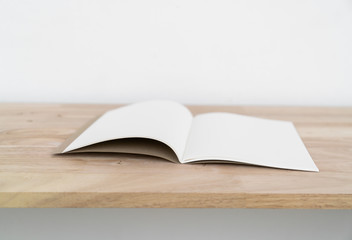 Blank catalog, magazines, book on wood background.