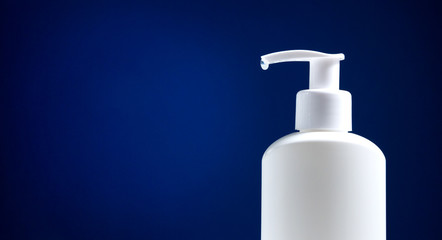White sanitizer bottle on a dark blue background.