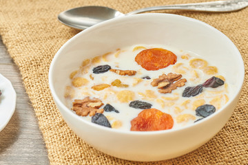 Corn bowl with fresh milk and dried fruits on the plate