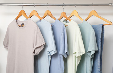 Stylish male clothes on hanger in wardrobe