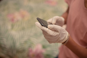 Young boy using his cellphone while wearing latex gloves