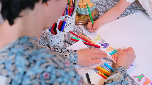 Family School, COVID 19. Mom with children draws on paper. Organization of the educational process in the self-isolation of the house. Stress relief.