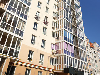 Lviv, Ukraine - 3 4 2020: Facade of a tall multi-storey modern house with balconies and large glass windows. Design of modern architecture. Top view from the bottom. Modern city architecture